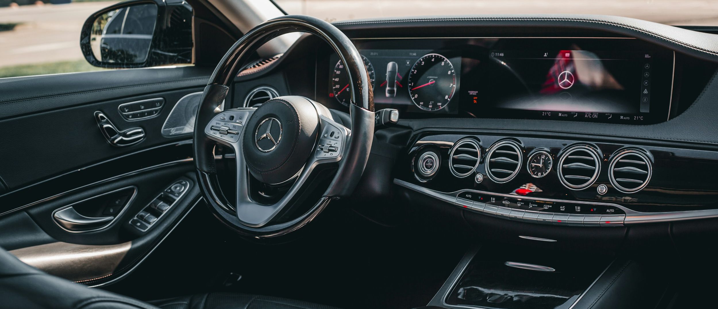 Chauffeur standing beside a black Mercedes